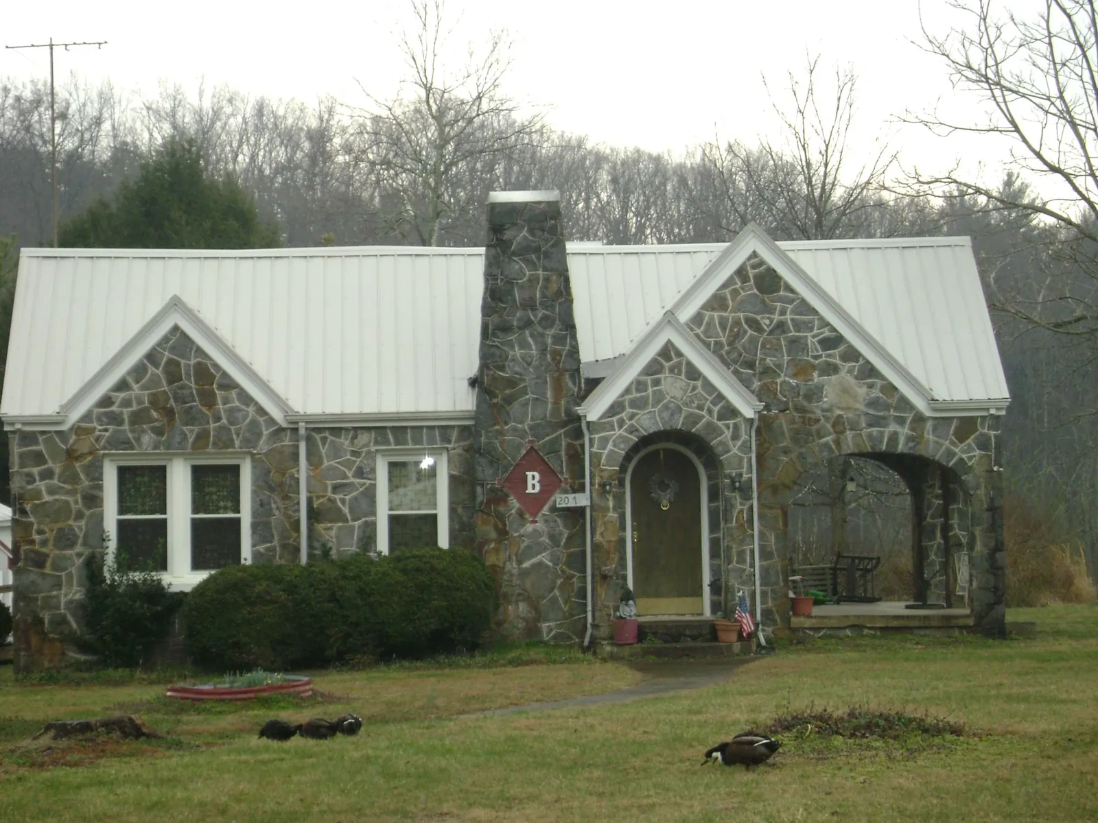 White metal roof on a stone cottage with steep gables in Toppenish