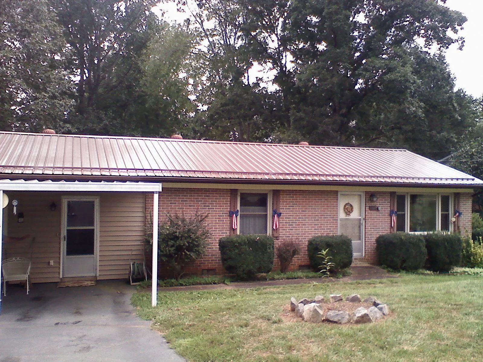 Bronze metal roof and carport on a brick ranch home — Roof Repair work by our crew in Toppenish